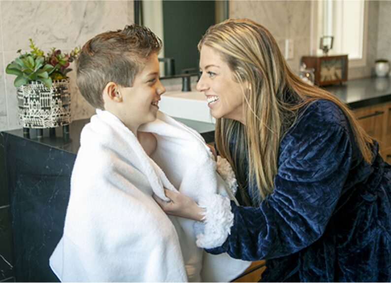 Mother wrapping her young son in a warm towel after his bath